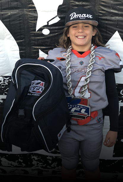 large silver chain necklace, holding a black backpack with NFL patches.